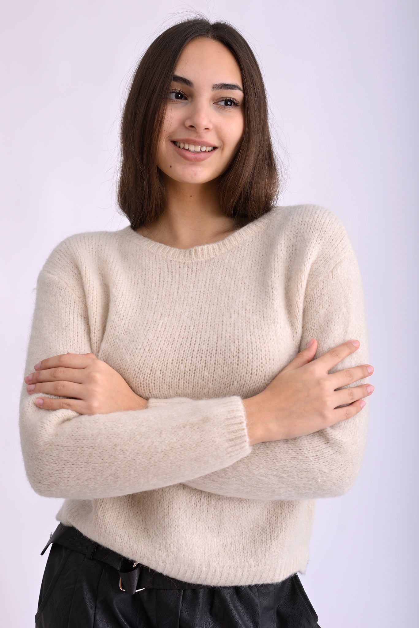 Model poartă pulover tricotat albastru intens, cu mânecă lungă și croială lejeră, pe fundal alb.