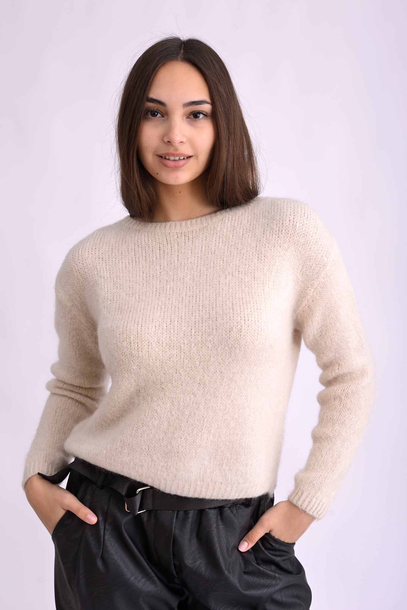 Model poartă pulover tricotat bej, cu mânecă lungă, din amestec de mohair și lână, croială lejeră.