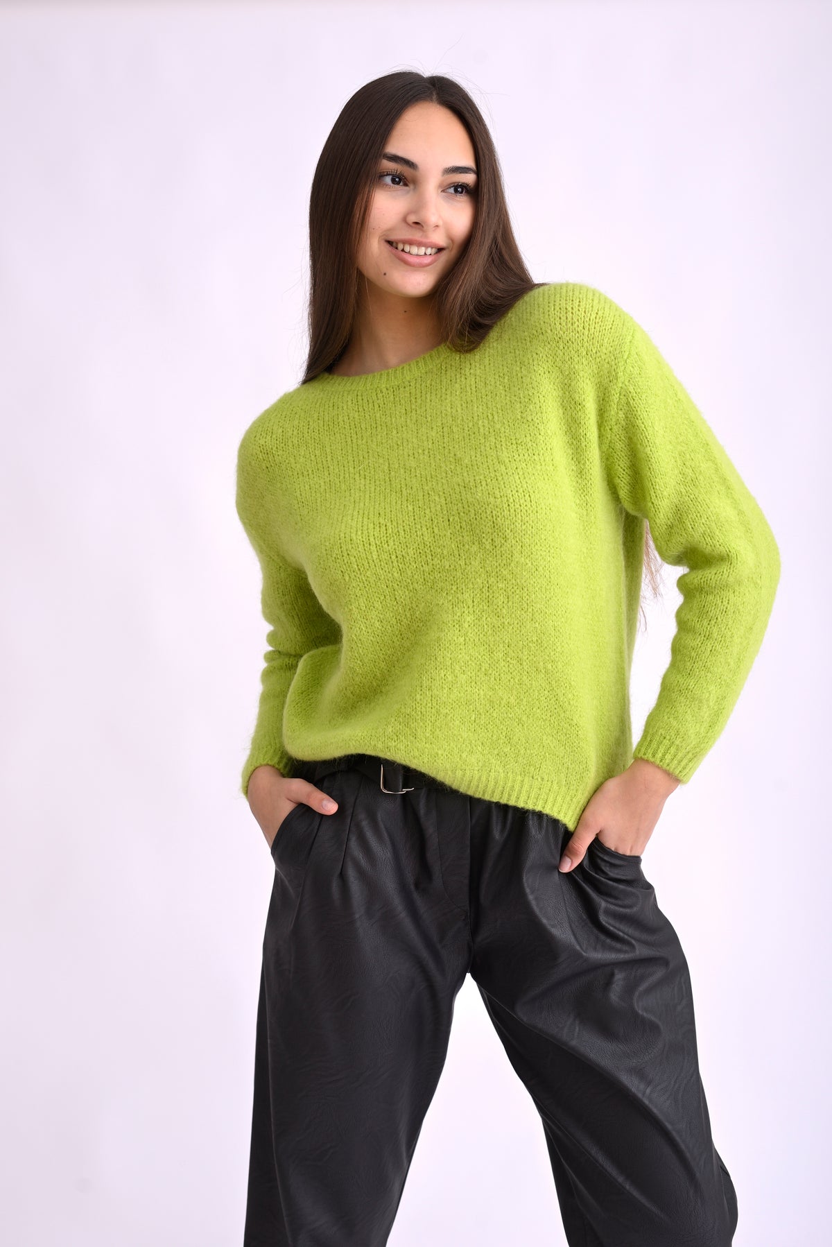 Pulover verde tricotat cu mânecă lungă, fotografiat lateral, evidențiind textura moale și croiala lejeră.