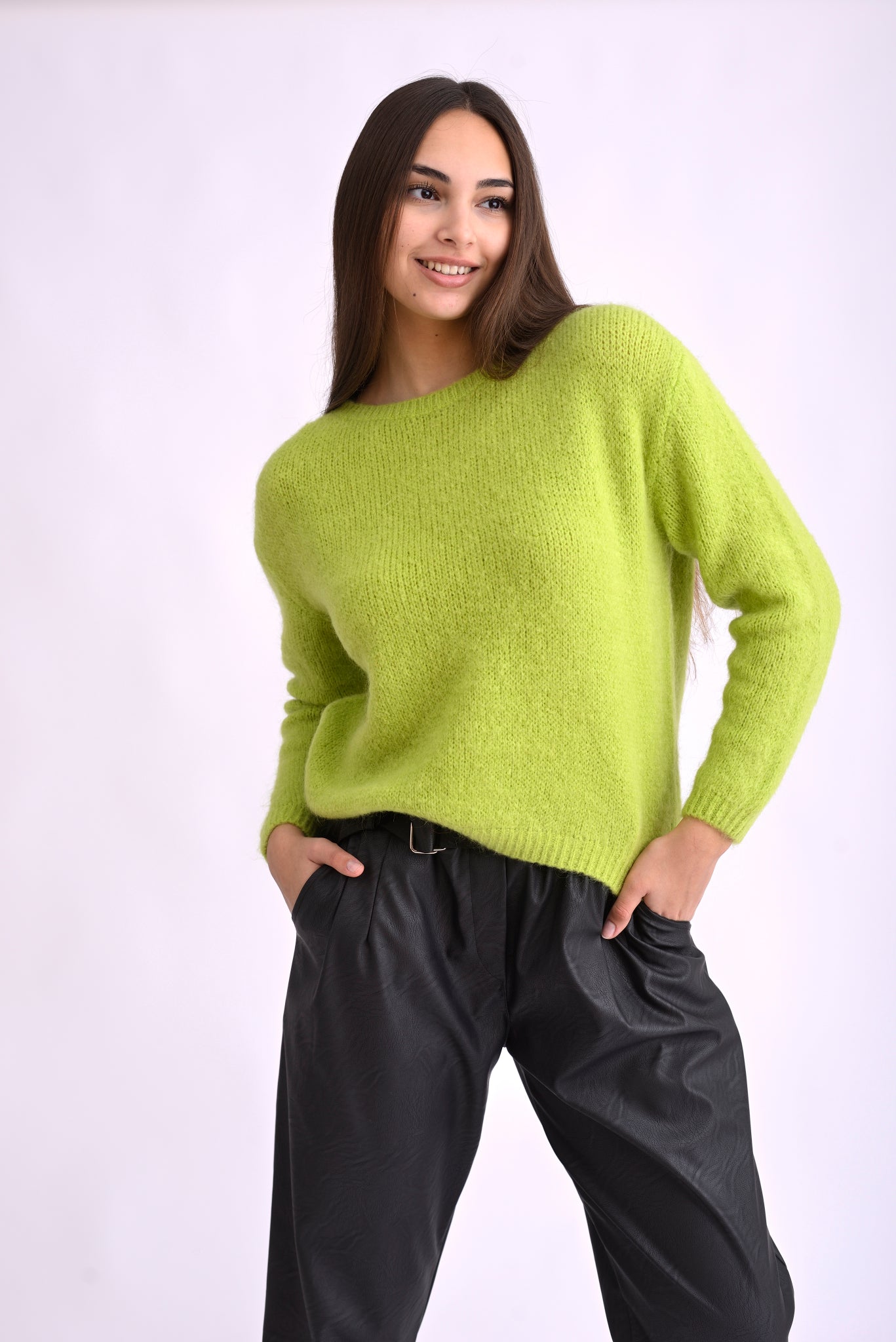 Pulover verde tricotat cu mânecă lungă, fotografiat lateral, evidențiind textura moale și croiala lejeră.