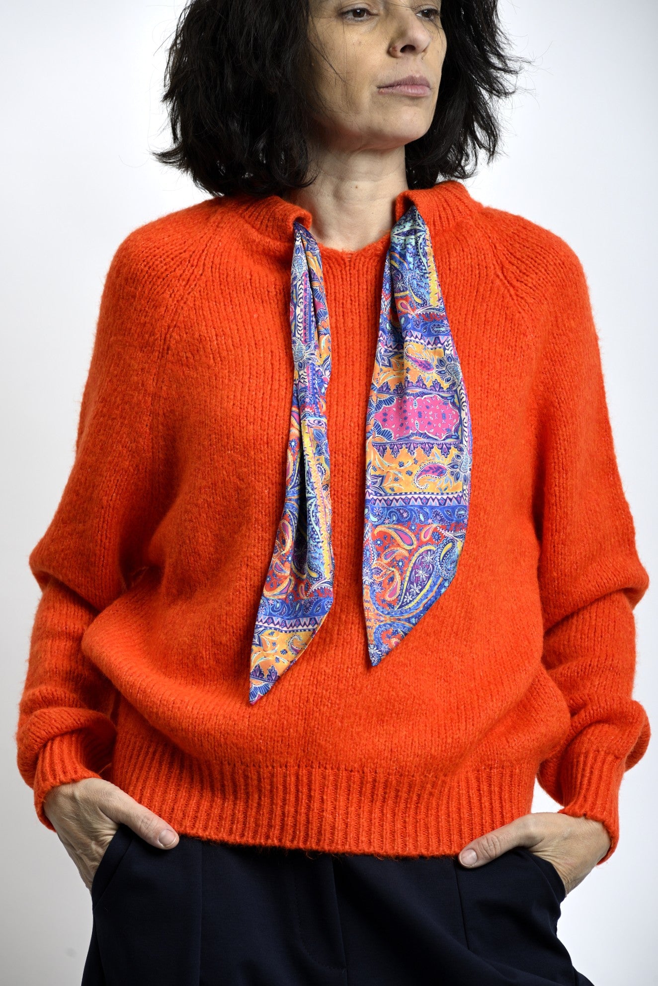 Pulover tricotat portocaliu cu guler rotund, croială lejeră și finisaje rib la bază și manșete.