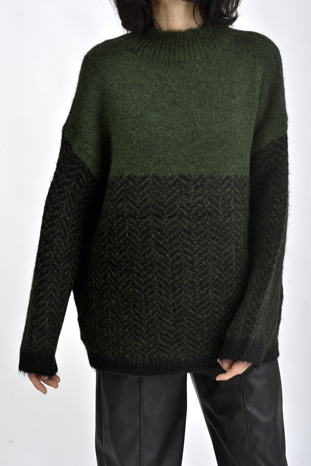 Pulover verde tricotat cu mâneci lungi și croială lejeră, fotografie semiprofil.