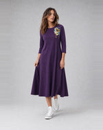 Rochie evazată din jerse cu floare imprimată pe umăr, în nuanța violet închis, purtată pe model, All Above Boutique