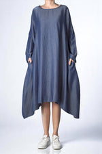 Rochie albastră asimetrică din Tencel cu mâneci lungi, croială lejeră și buzunare laterale.
