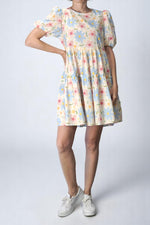  Rochie babydoll cu imprimeu floral pastel, în nuanțe de bleu și roz, văzută din față.