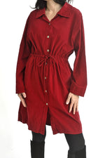 Vedere laterală rochie cămașă reiată, cu șiret reglabil în talie și buzunare.