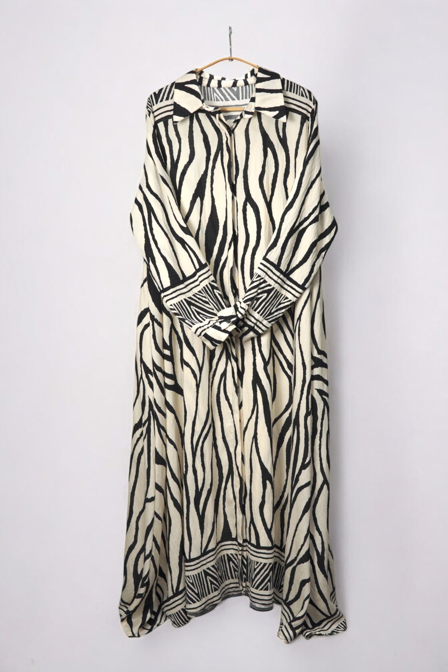 Rochie lungă tip cămașă, cu imprimeu zebra alb-negru, croială fluidă și detalii de nasturi.