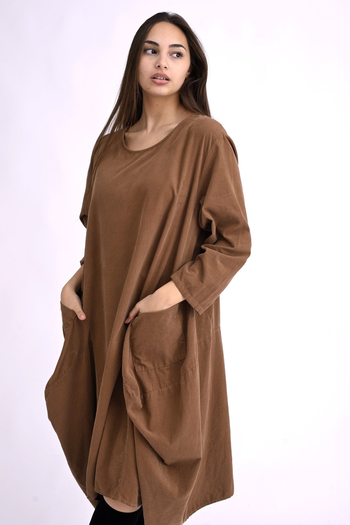 Rochie bej din catifea reiată, din bumbac 100%, cu croială amplă și buzunare laterale, purtată pe model.