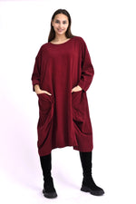 Rochie din catifea reiată bordo, cu buzunare voluminoase și croială amplă, purtată pe model, vedere din față.