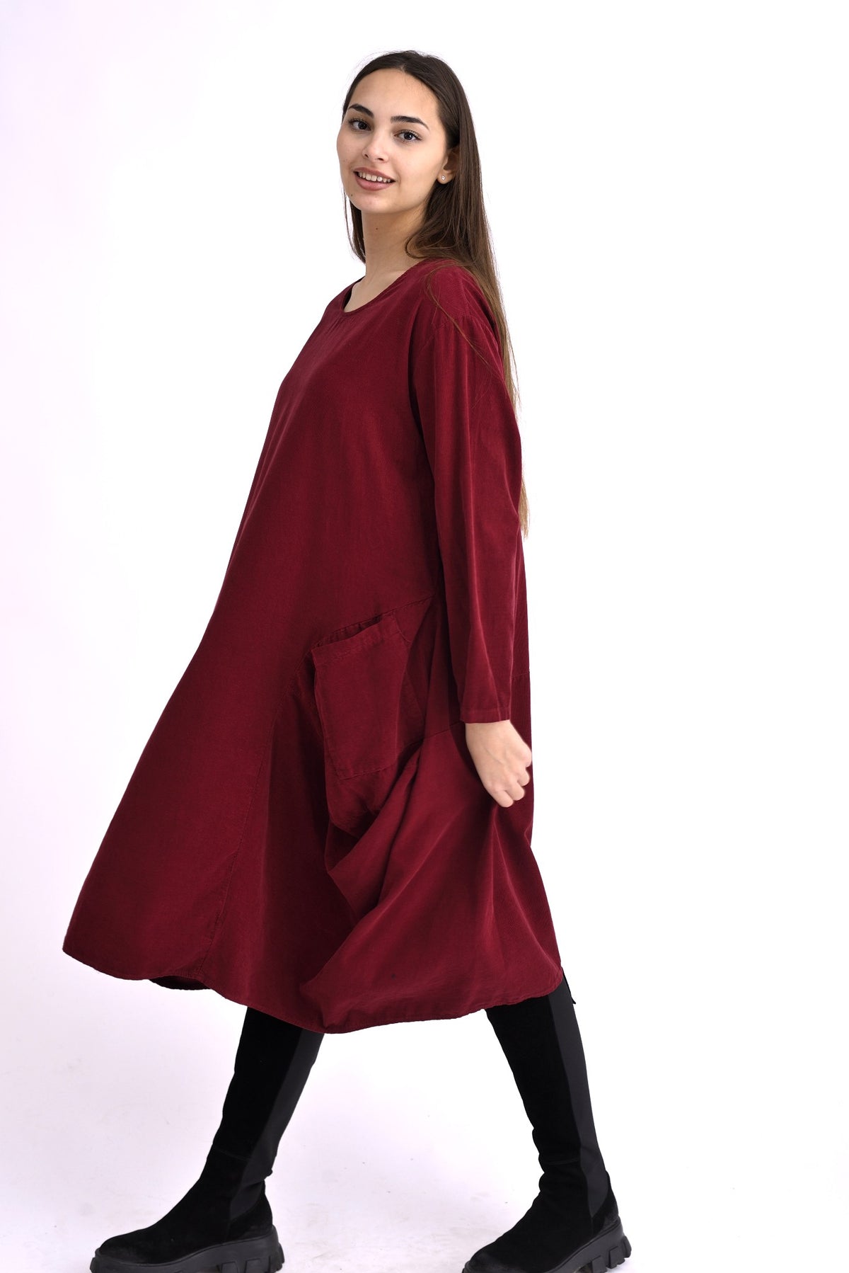 Rochie neagră din catifea reiată, croială lejeră și buzunare mari, purtată pe model, vedere frontală.