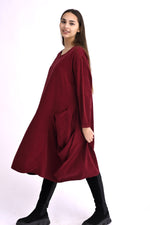 Rochie neagră din catifea reiată, croială lejeră și buzunare mari, purtată pe model, vedere frontală.