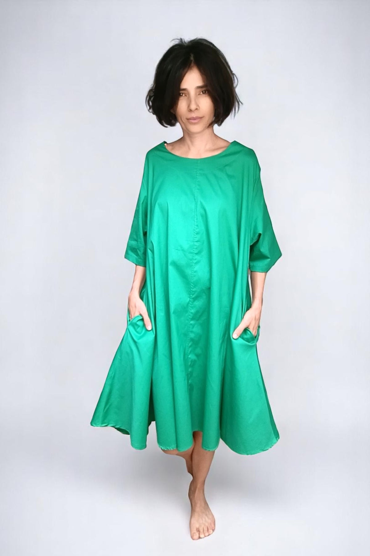 Rochie verde intens tip clopot, cu croială largă și mâneci până la cot, fotografiată din față