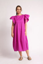 Detaliu rochie fucsia cu mâneci voluminoase și decolteu rotund.