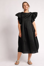 Rochie neagra cu mâneci voluminoase și decolteu rotund.