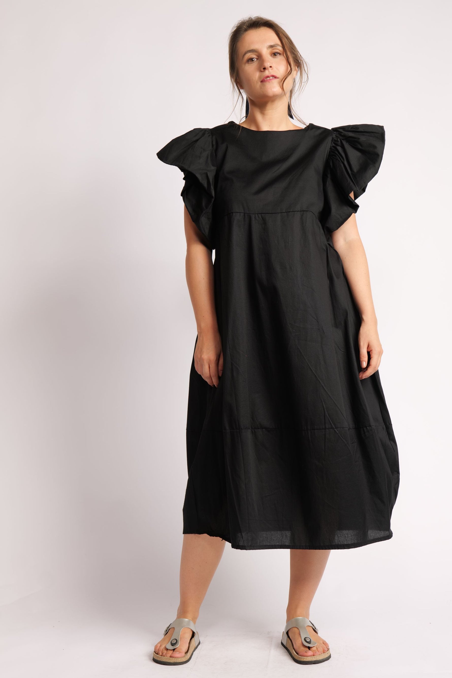 Rochie neagra cu mâneci voluminoase și decolteu rotund.