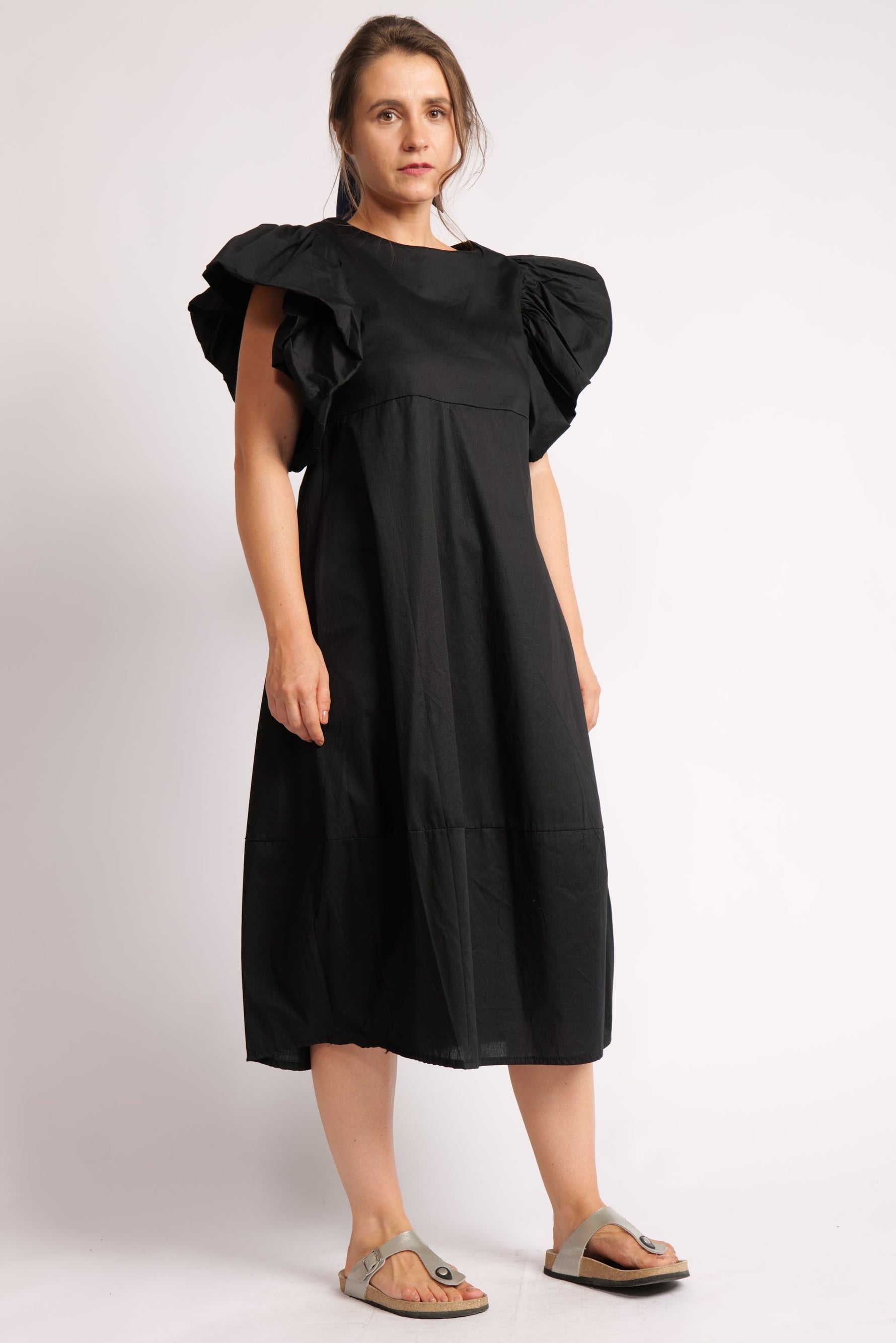 Rochie neagra cu mâneci voluminoase și decolteu rotund.