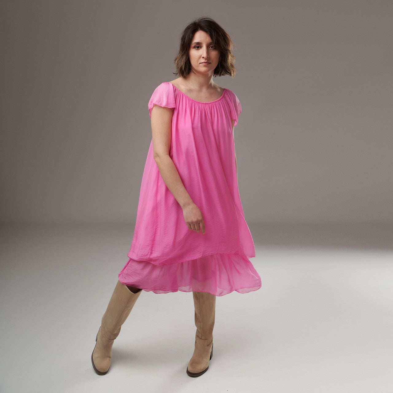 Rochie roz intens cu croială lejeră și volan lat la bază, purtată de model