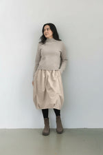 Detaliu de textură tafta cu pliuri decorative pe rochia cu bretele.