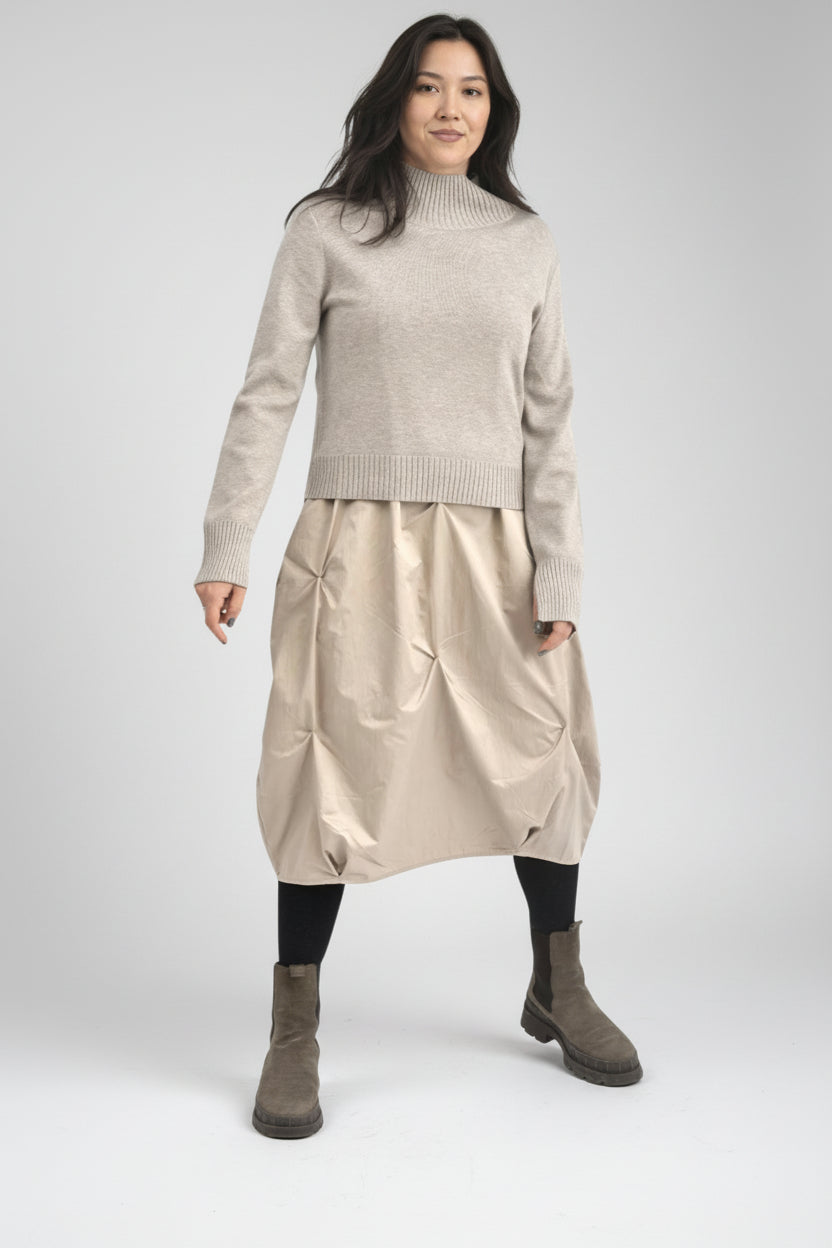 Rochie două piese cu pulover tricotat și rochie cu bretele, purtată într-o ținută casual-elegantă.