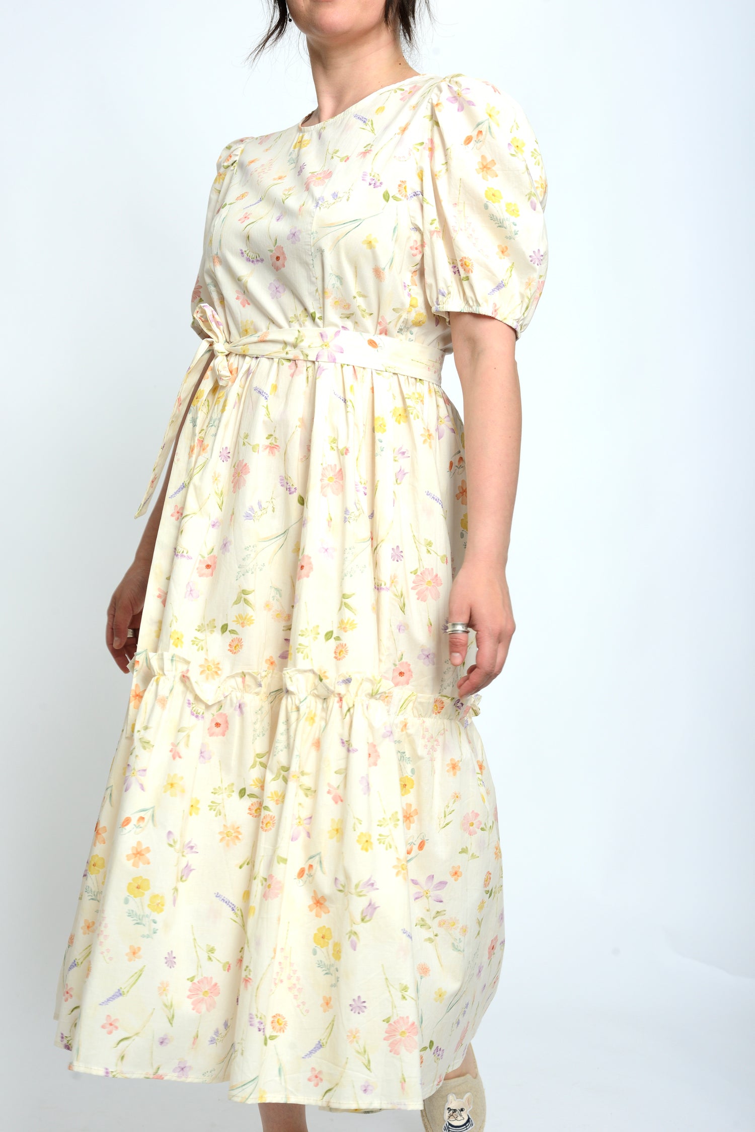  Rochie bej cu imprimeu floral în nuanțe pastel, croială cu volane și talie marcată