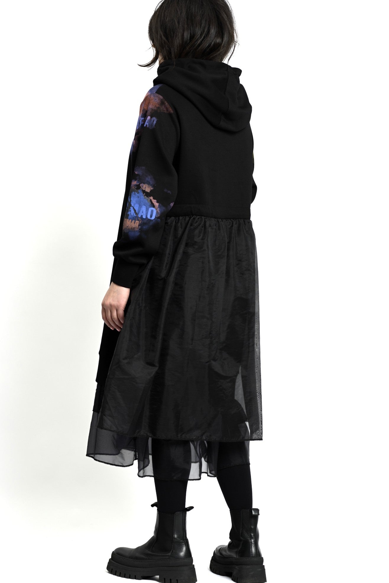 Detaliu de mânecă cu print artistic tip splash, pe fundal negru mat.