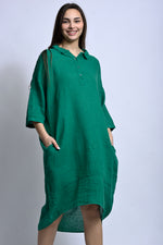 Rochie din in cu mâneci 3/4 și croială lejeră, cu linie fluidă și buzunare laterale, purtată frontal.