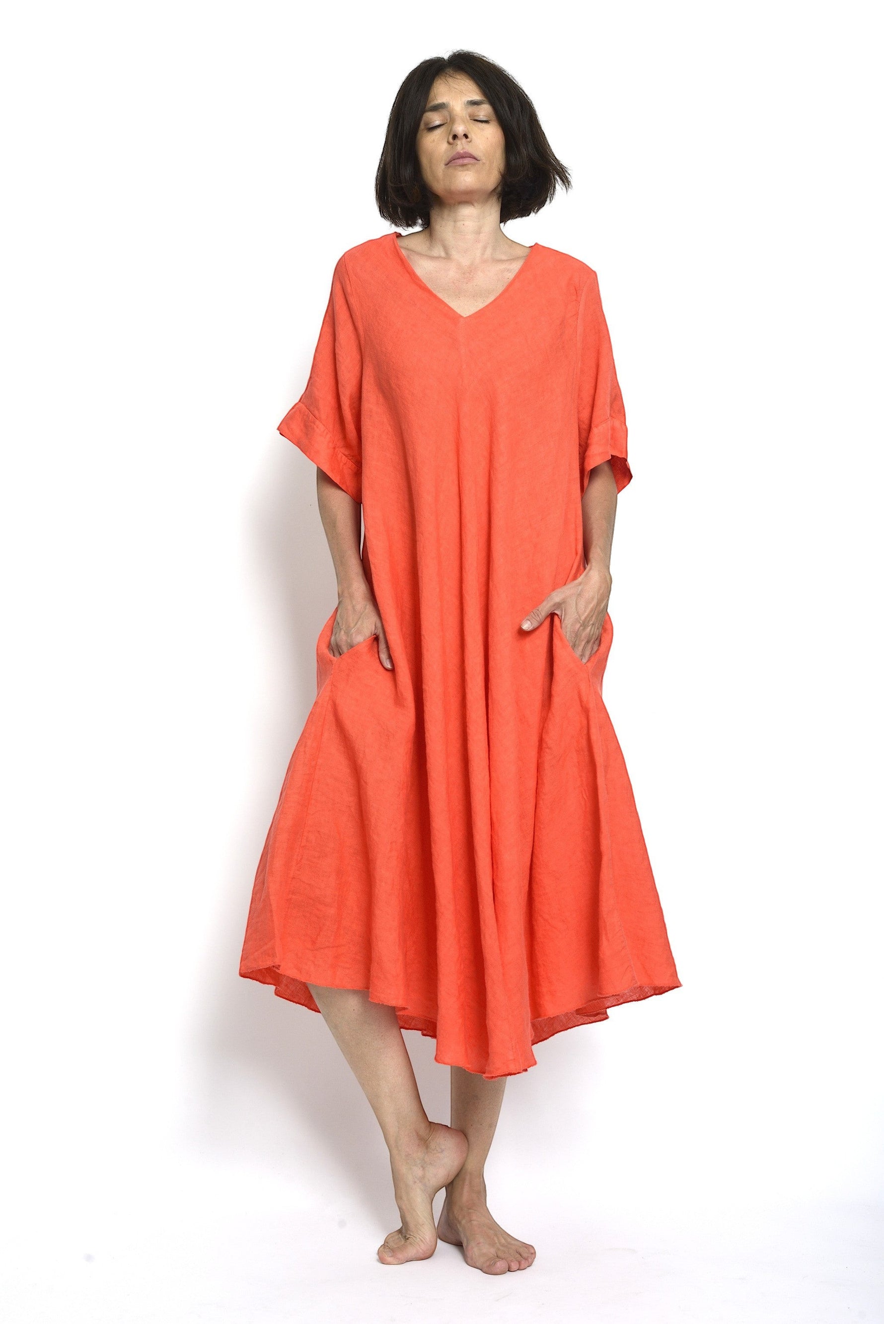 Rochie din in de culoare coral, lejeră și vaporoasă, cu mâneci scurte și buzunare laterale, vedere frontală completă