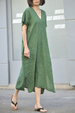 Rochie verde lungă din in 100%, fotografiată în mers, cu textură aerisită.