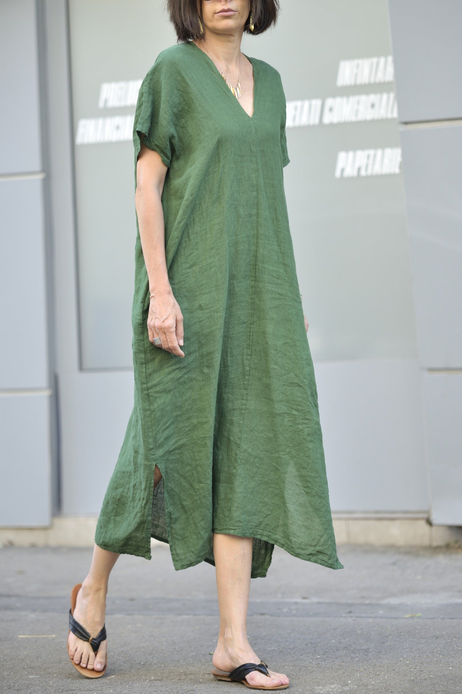 Rochie verde lungă din in 100%, fotografiată în mers, cu textură aerisită.