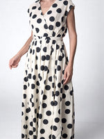 Rochie lungă albă cu buline negre, cu croială petrecută, curea în talie și lungime maxi. All Above Boutique.