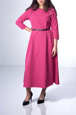 Rochie lungă roz fucsia cu mâneci trei sferturi, buzunare laterale și centură neagră subțire.