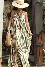 Rochie lungă vaporoasă cu imprimeu tropical verde, purtată cu pălărie de paie