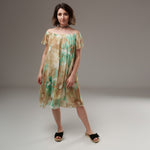 Rochie vaporoasă din mătase naturală cu imprimeu floral în bej și verde mentă, purtată pe umeri