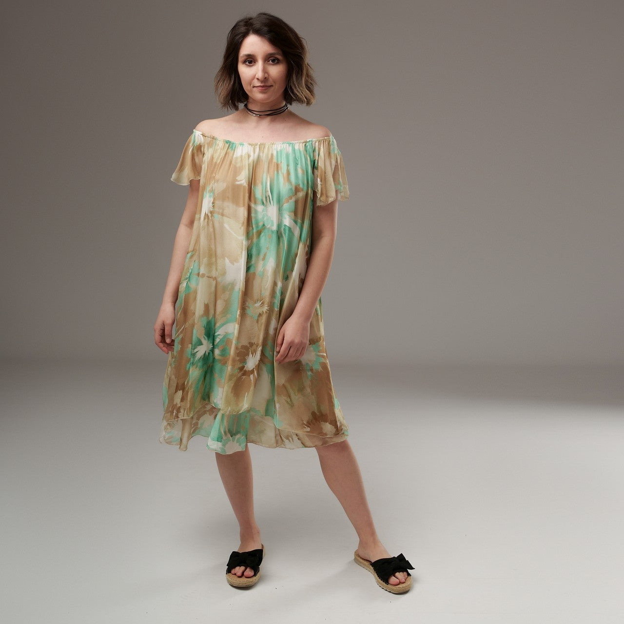 Rochie vaporoasă din mătase naturală cu imprimeu floral în bej și verde mentă, purtată pe umeri