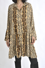 Rochie din mătase cu imprimeu etnic purtată lejer, evidențiind volumul și căderea naturală a materialului.