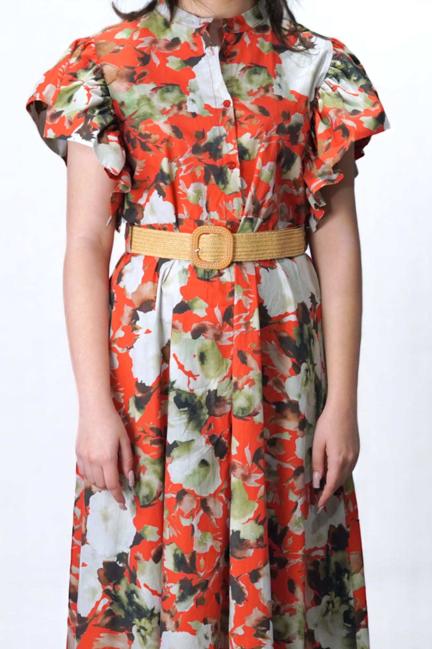Detaliu bust și guler rochie midi cu nasturi și imprimeu floral în nuanțe vibrante, accesorizată cu curea bej.