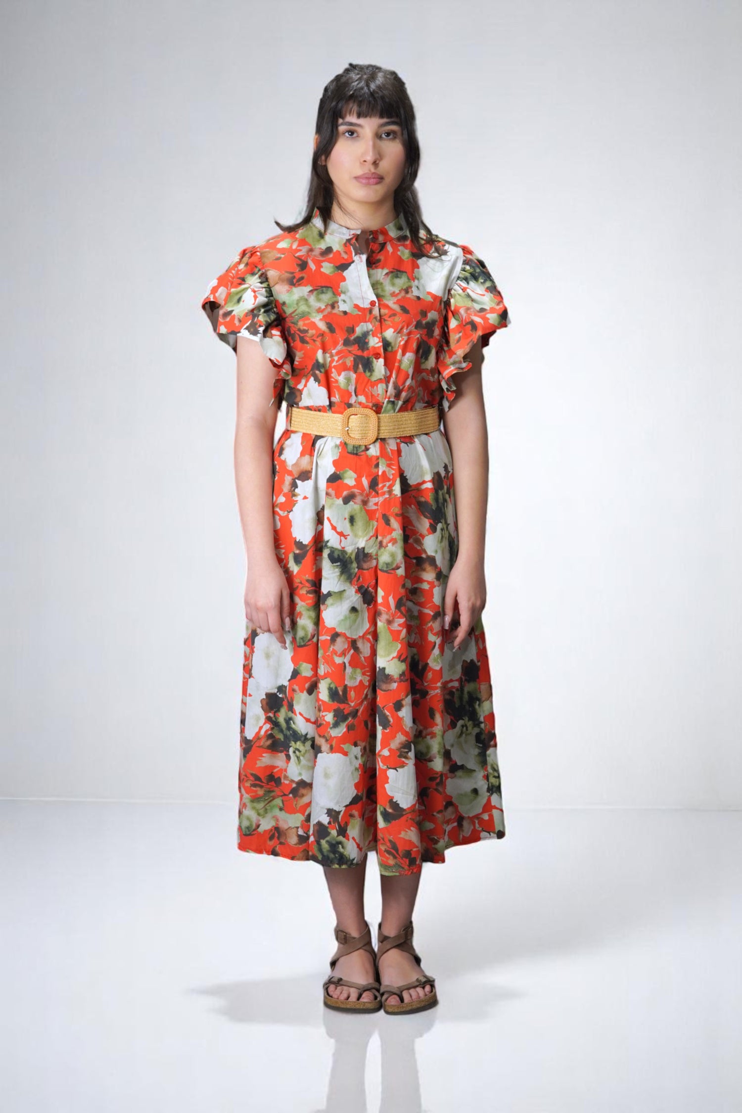  Rochie midi cu imprimeu floral intens, croială lejeră și volan amplu la umeri, model fotografiat din față.