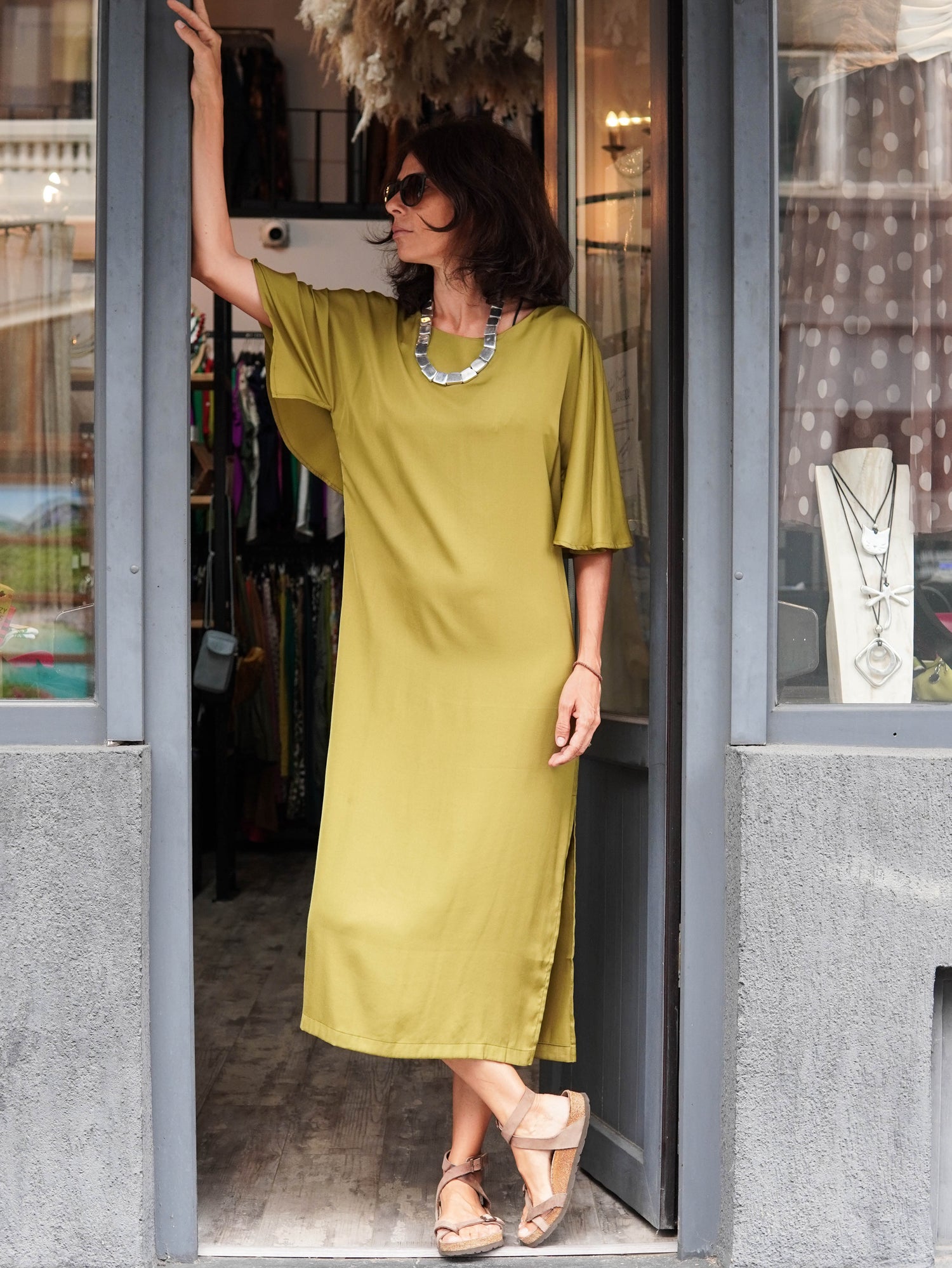  Rochie midi din viscoză cu mânecă evazată, material satinat cu reflexii, croială fluidă și decolteu rotund.