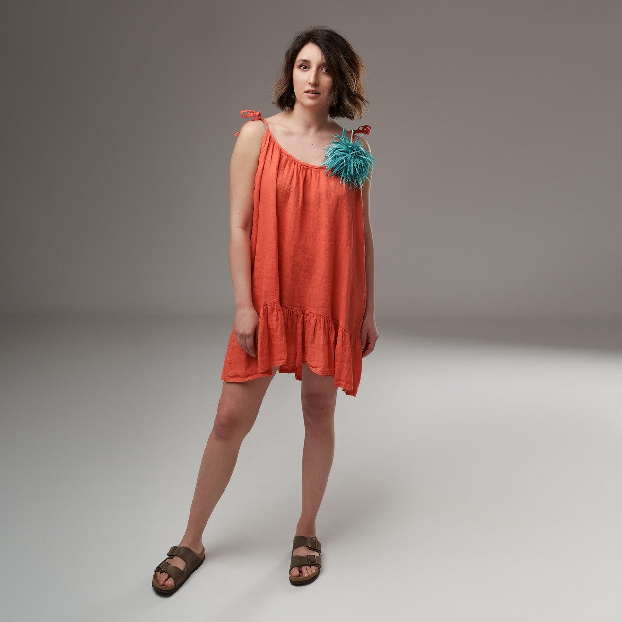 Rochie mini din in vaporoasă, oranj, cu bretele reglabile subțiri și volan încrețit la tiv, decorată cu floare textilă aplicată.