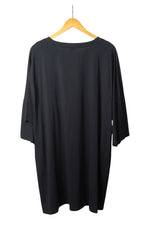 Spatele unei rochii lungi negre, cu croială lejeră și material moale, perfectă pentru un look confortabil.