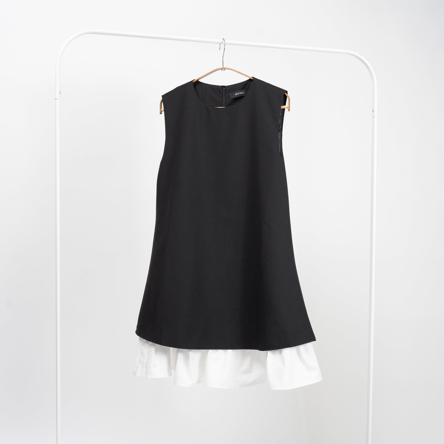 Rochie neagră fără mâneci, cu croială evazată și volan alb decorativ, vedere frontală completă.