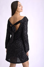 Rochie scurtă neagra cu paiete și mâneci lungi, decorată cu fundă elegantă la spate.