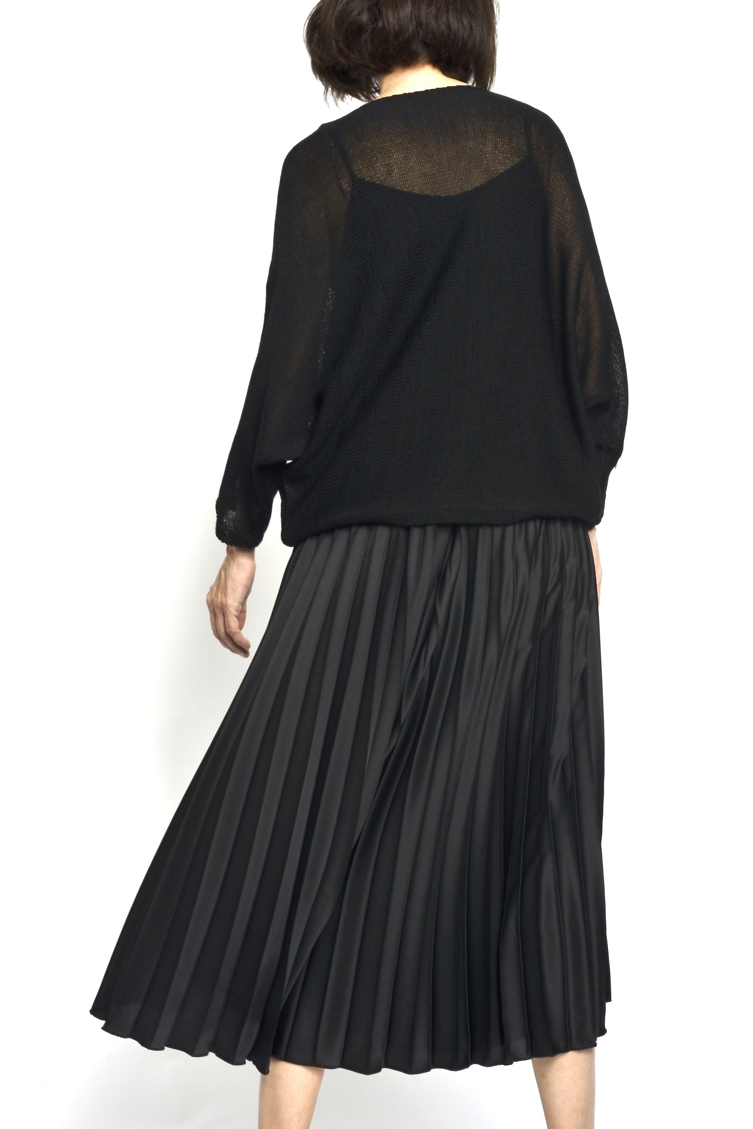 Rochie plisată lungă din două piese, văzută din spate, cu top negru transparent și fustă cu volum