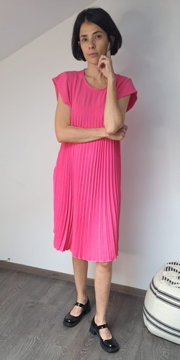  Rochie plisată scurtă într-o nuanță roz vibrant, cu croială confortabilă și detalii fluide.