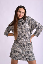 Detaliu de material al rochiei tricotate cu imprimeu alb-negru, textură moale și guler înalt tip turtleneck.