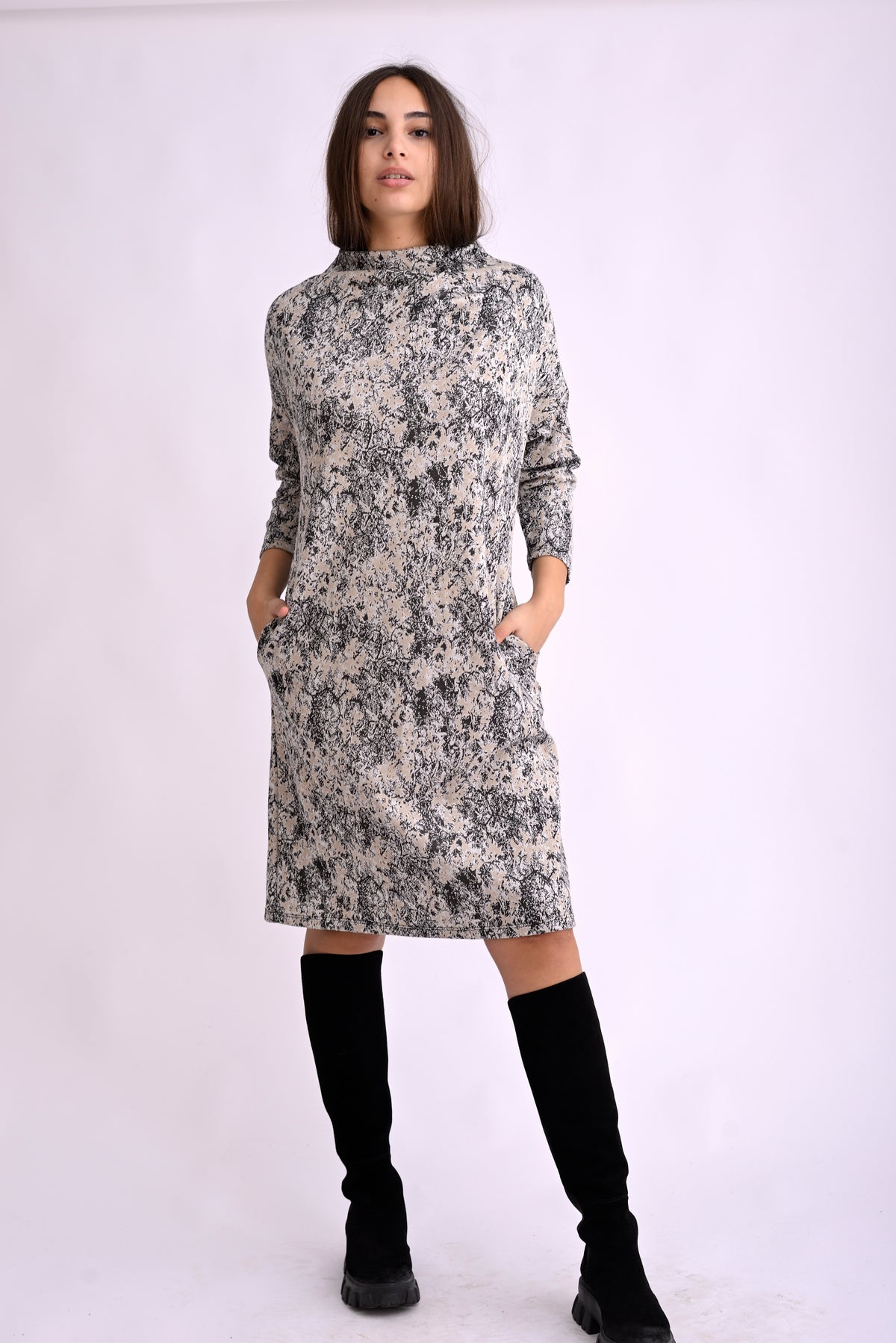 Rochie lejeră cu print abstract alb-negru, guler înalt tip turtleneck și mâneci lungi, purtată pe model, vedere din față.