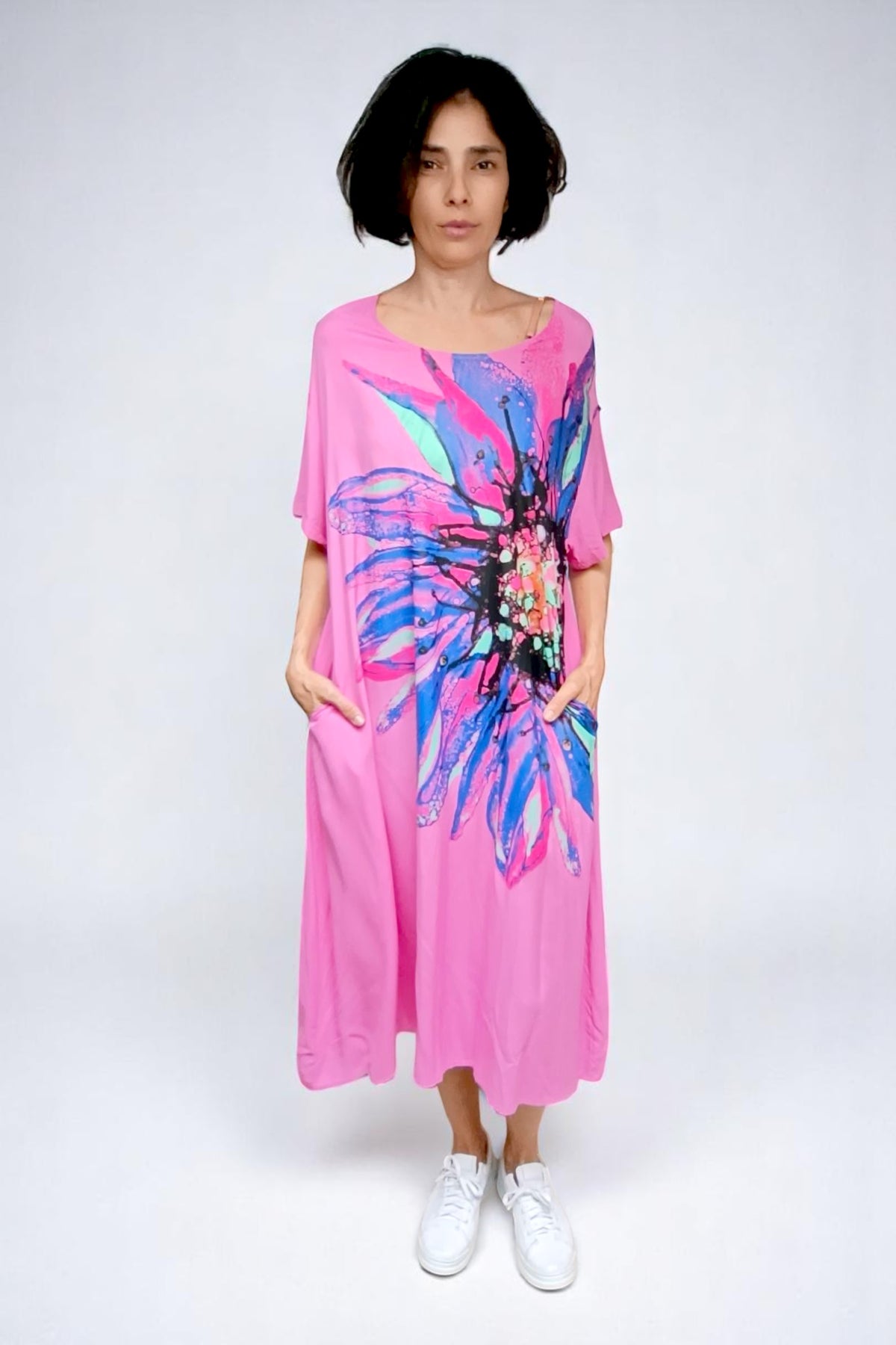 Model purtând rochia roz cu croi lejer, mâneci scurte și imprimeu floral vibrant