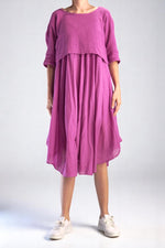 Rochie midi roz cu aspect relaxat, purtată de model cu pantofi sport.