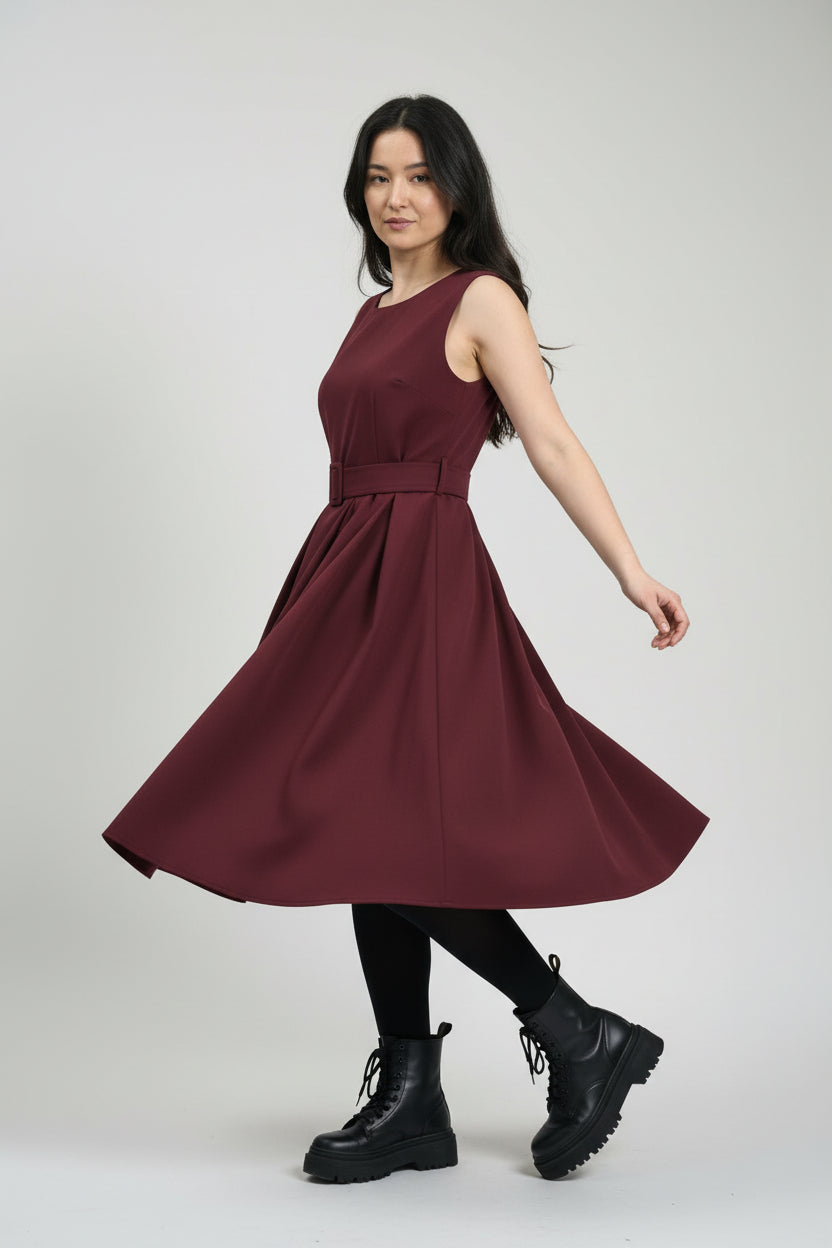 Rochie sarafan bordo cu pliuri fluide, surprinsă în mișcare, evidențiind volumul fustei.
