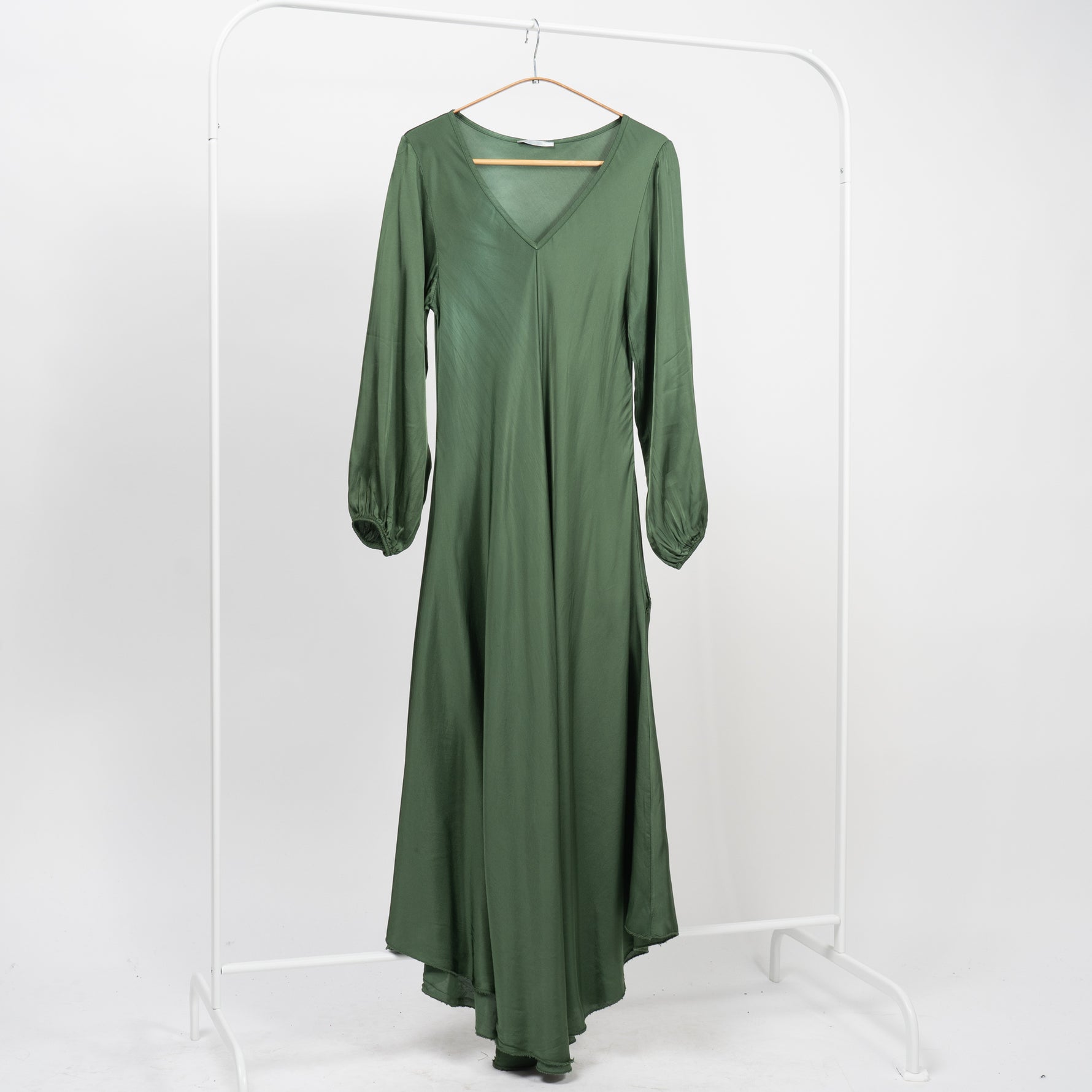  Rochie lungă din satin verde, cu decolteu în V și mâneci lungi elastice, pe umeraș alb.
